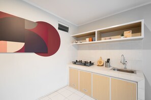 Una cocina moderna con estufa integrada, un lavamanos y un salpicadero decorativo.