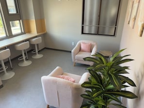 A modern interior with a seating area, a bar counter, and a large window.