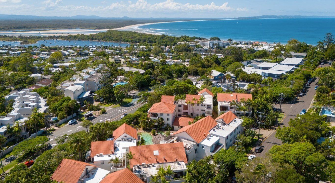 Une ville côtière avec des immeubles résidentiels, une plage et un port de plaisance.
