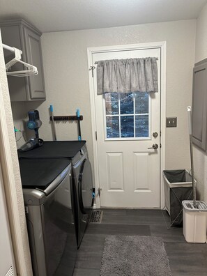 A laundry room with a washing machine, dryer, and a window with a view of trees. - Beautiful, cozy 3 bedroom, two bath, private home on acreage in the mountains (Lava Hot Springs)