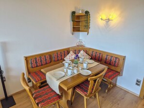 A dining area with a wooden table set for four, surrounded by patterned benches. - Urban&Florian Top 101 by Interhome (Sankt Urban)