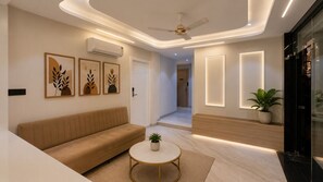 Una sala de estar moderna con un sofá, una mesa de centro y aire acondicionado instalado en la pared.
