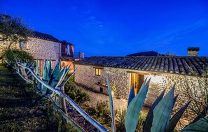 A stone house with a tiled roof, surrounded by agave plants, under a twilight sky. - Stunning home in Monte San Martino (Monte San Martino)