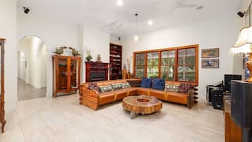 A spacious living room with a sectional sofa, a wooden coffee table, and a fireplace.