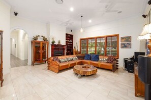 Un salon spacieux avec un canapé d’angle, une table basse en bois et une cheminée.