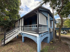 Una casa azul con un porche y una escalera.