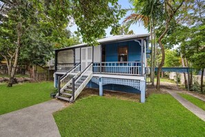 A two-story house with a blue exterior, a front porch, and a staircase leading to the upper floor. - Charming Queenslander | Sleeps 6 | Near CBD & Park (Newmarket)