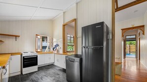 A kitchen with a stove, oven, dishwasher, and a large black refrigerator.