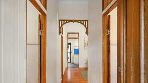 A hallway with wooden doors and a wooden floor.