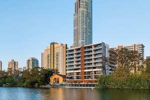 A high-rise building with a modern design, situated near a body of water with a dock. - Waterfront 2B 2Bath Pk,GYM,Pool&BBQ (Surfers Paradise)
