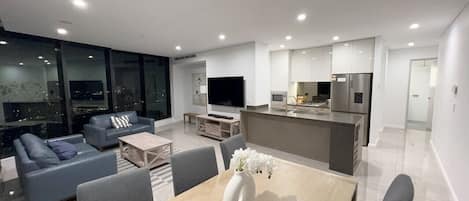 A modern living room with a sofa, coffee table, and TV.