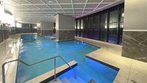 En inomhuspool med ett kaklat golv och ett tak med ett rutmönster.