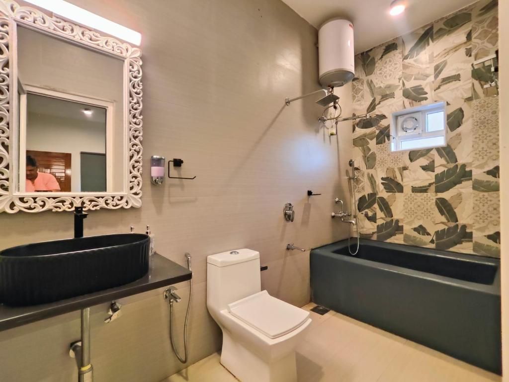 Ein Badezimmer mit einem schwarzen Waschbecken, einer weißen Toilette und einer Badewanne.