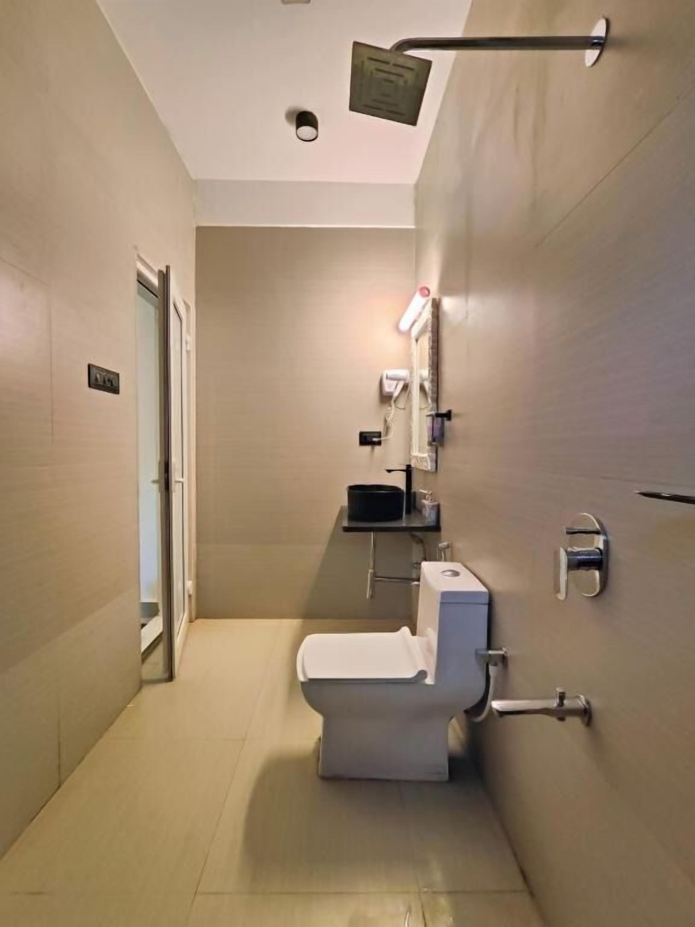 Un baño moderno con inodoro, lavamanos y ducha.