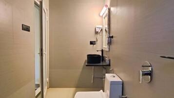 Un baño moderno con inodoro, lavamanos y ducha.