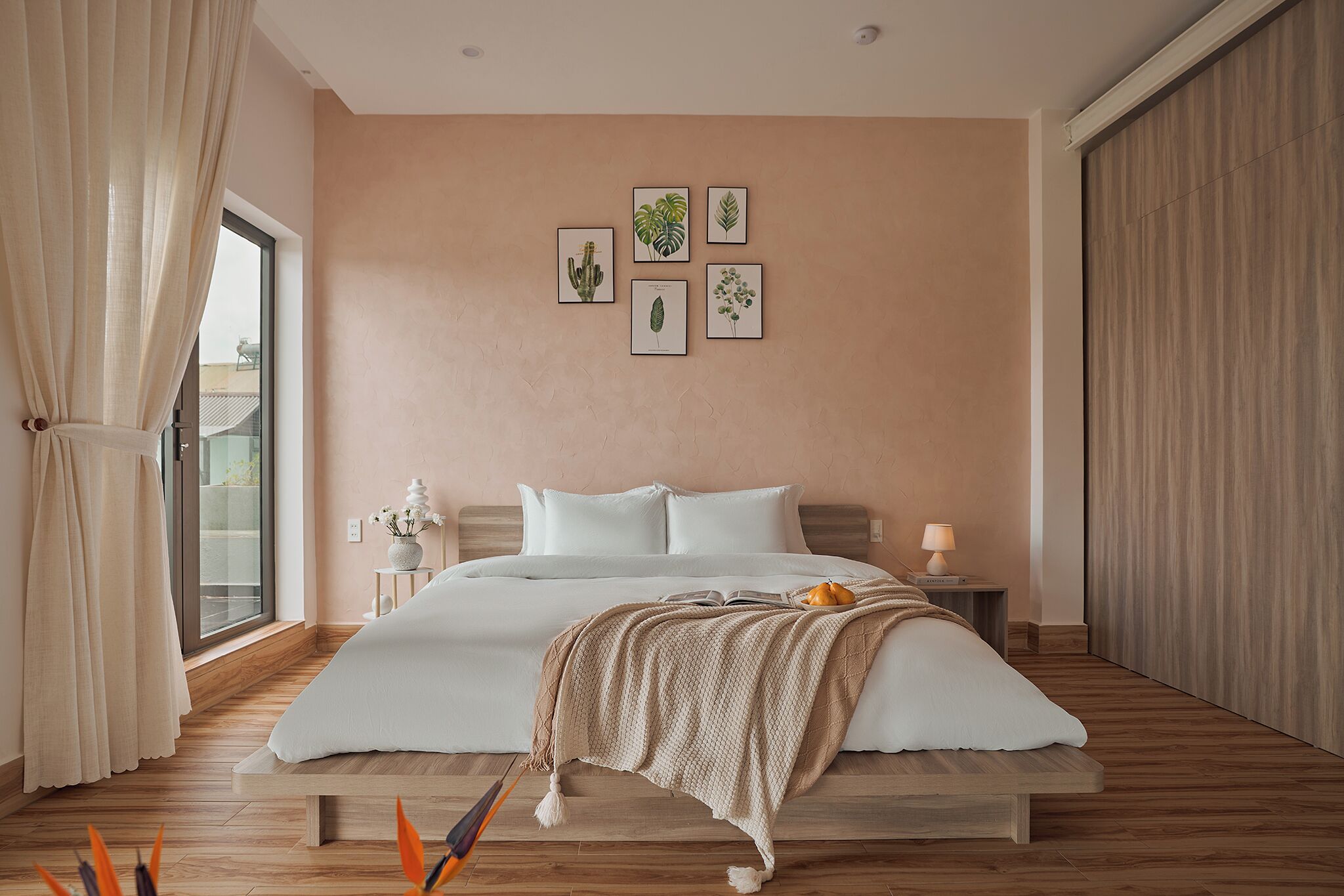 A bedroom with a bed, a nightstand, a lamp, and a window with curtains.