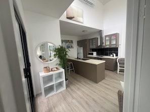 A compact kitchen with a central island, a microwave, and a refrigerator.