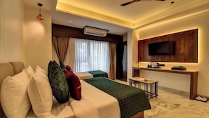 Una habitación de hotel moderna con cama, escritorio, televisión de pantalla plana y aire acondicionado.