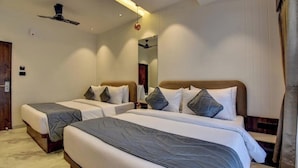 Habitación de hotel con dos camas, un ventilador de techo y un espejo.