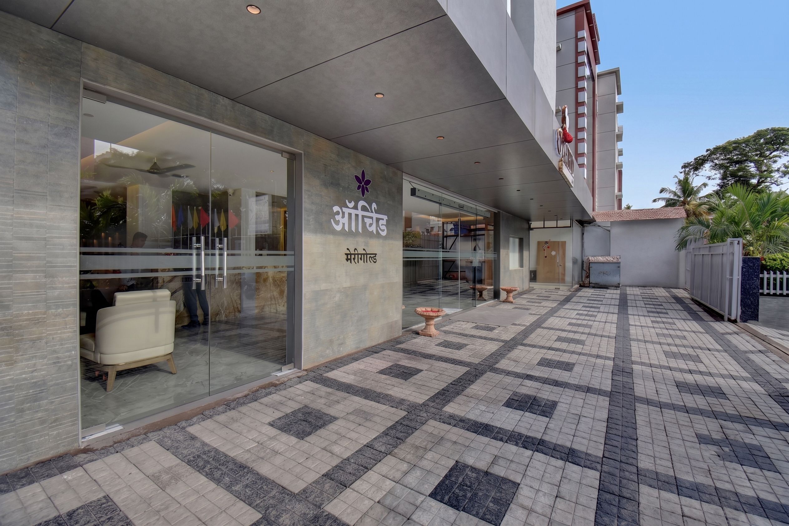 A modern building with a glass storefront and a tiled walkway.