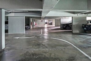 A parking garage with concrete floors and multiple parking spaces. - Ocean view apartment near Piscadera beach (Curacao)