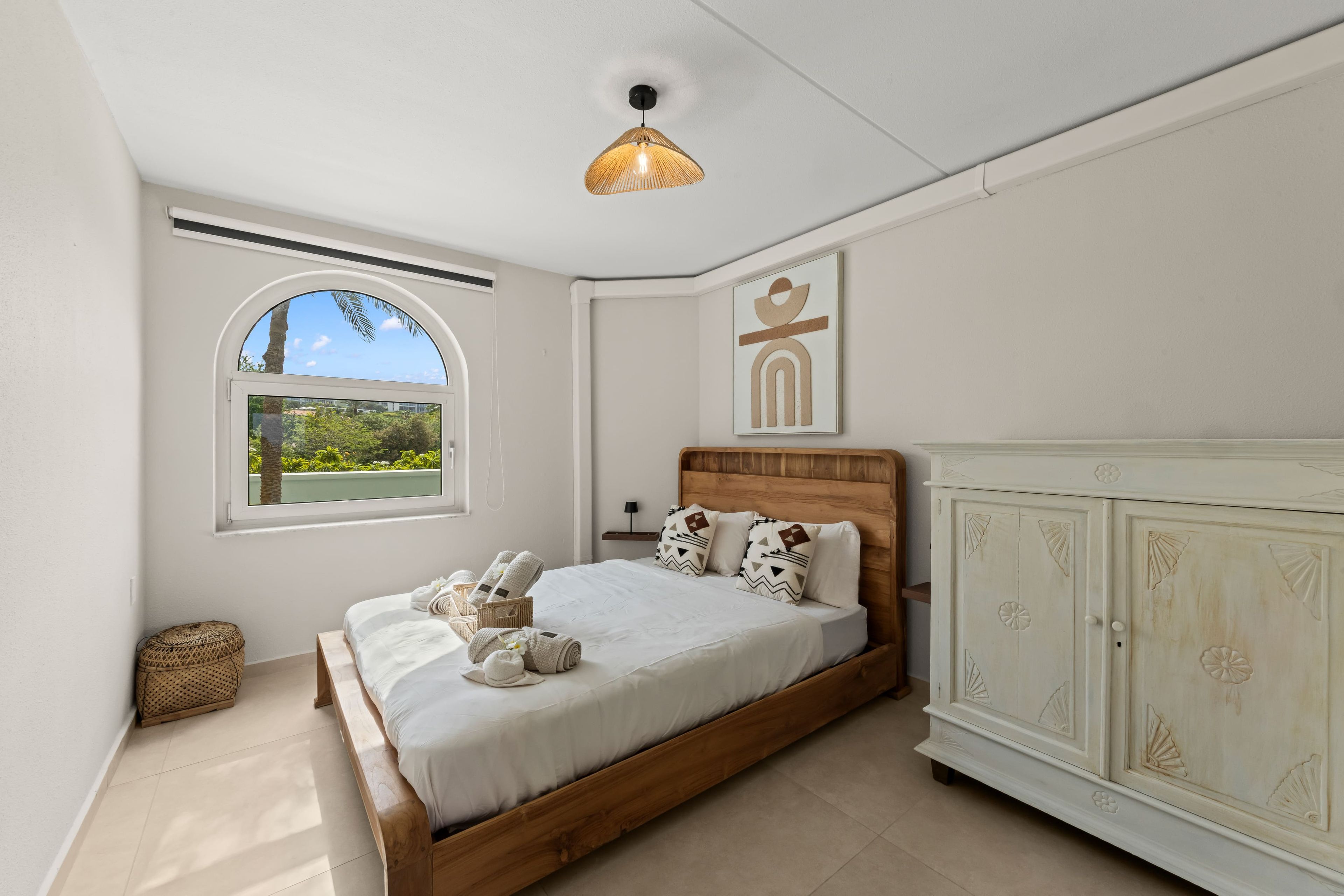 Une chambre à coucher avec un lit, une fenêtre, une armoire et un luminaire suspendu.