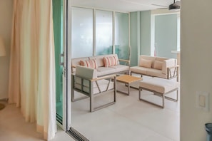 A modern living room with a sofa set, a coffee table, and a glass partition. - Ocean view apartment near Piscadera beach (Curacao)
