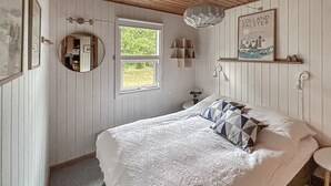 A bedroom with a bed, a window, a mirror, a wall-mounted shelf, and a picture. - 3 bedroom gorgeous home in Rødby (Rødby)