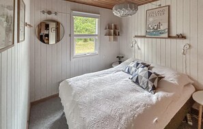 A bedroom with a bed, a window, a mirror, a wall-mounted shelf, and a picture. - 3 bedroom gorgeous home in Rødby (Rødby)