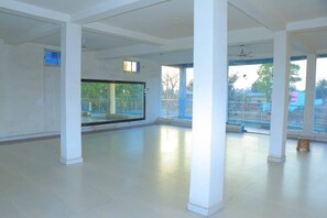 A spacious room with large windows, a ceiling fan, and a visible balcony.