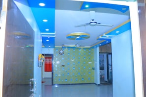 A room with a ceiling fan, recessed lighting, and a wall with a nautical-themed design.
