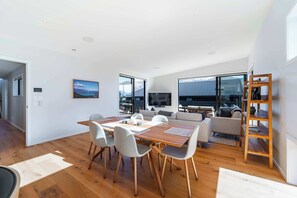Ein zeitgemäßer Wohnbereich mit Essbereich, Sofas und Fernseher.