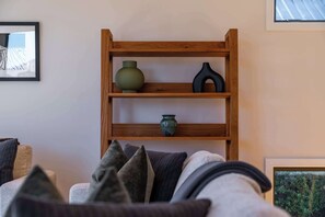 Ein Holzregal mit drei Vasen an einer Wand.