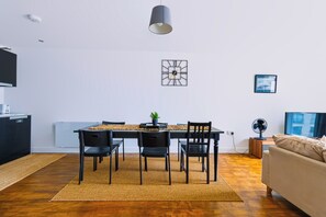 A modern living space with a dining area, a flat-screen TV, and a sofa. - Spacious 2-Bed 2-Bath Cardiff City Centre Apt (Cardiff)
