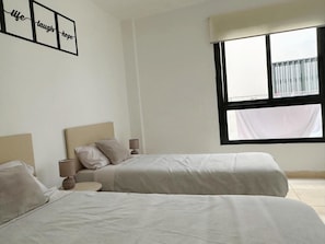 A bedroom with two beds, a window with a view, and a wall with a motivational quote. - Apartamento 'Estrella Del Sur Torremolinos' con vistas a la montaña, Wi-Fi y aire acondicionado (Torremolinos)