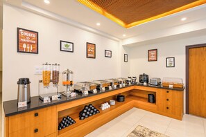 A buffet setup with various food dispensers, a coffee station, and multiple serving stations. - Terra Rose Suites By Bestinn Leisure (Bengaluru)