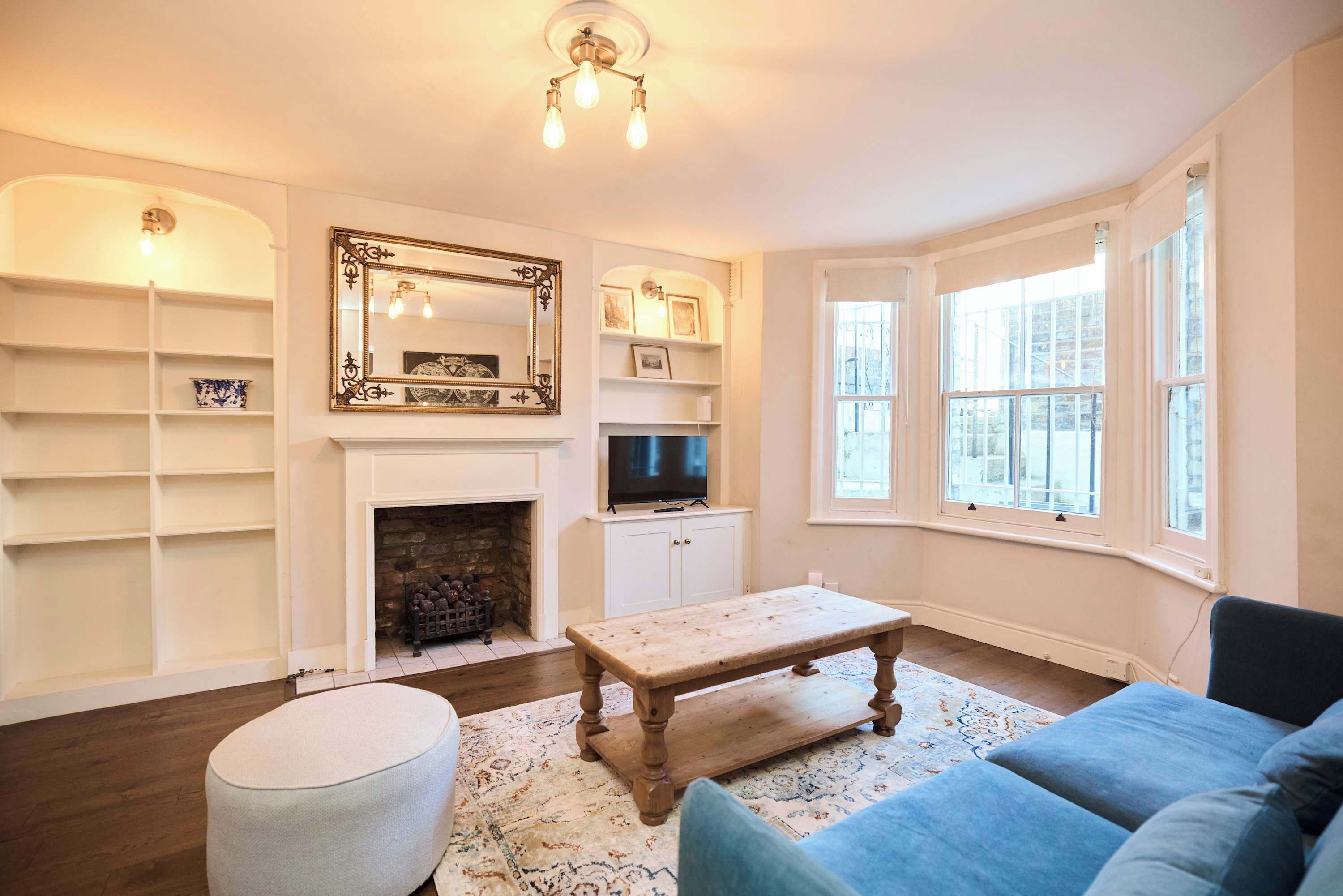 A living room with a fireplace, a television, a coffee table, and a sofa.