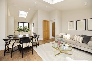 A spacious living room with a round dining table, a sofa, and a coffee table. - A Place to Dwell - Tooting (Greater London)