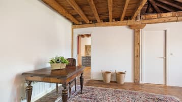 A room with a wooden table, a patterned rug, and a wooden ceiling.