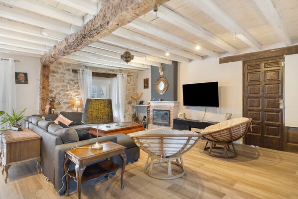 A spacious living room with a fireplace, a television, and a comfortable seating area.