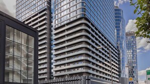 Ein modernes Hochhaus mit mehreren Stockwerken und einer Glasfassade.