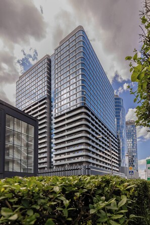 Ein modernes Hochhaus mit mehreren Stockwerken und einer Glasfassade.