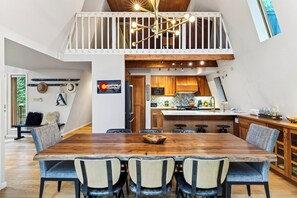 A spacious dining area with a high ceiling and a view of the kitchen below. - A-Frame + Hot Tub + Arcade + BBQ | Forest Views + Ski Access | Pitch & Pine (Breckenridge)