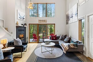 Un salon spacieux doté d’une cheminée, d’un coin salon et offrant une vue sur l’extérieur.