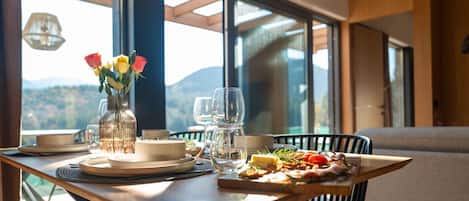 A dining table with plates, glasses, and a vase of flowers.