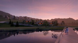 A serene lakeside setting with modern architecture, a wooden boardwalk, and a calm water body reflecting the surroundings.