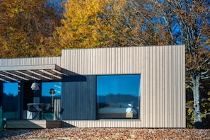 A modern, single-story building with a large glass window and a small balcony. - Infinity 4p in Vama Buz Ului (Vama Buzăului)