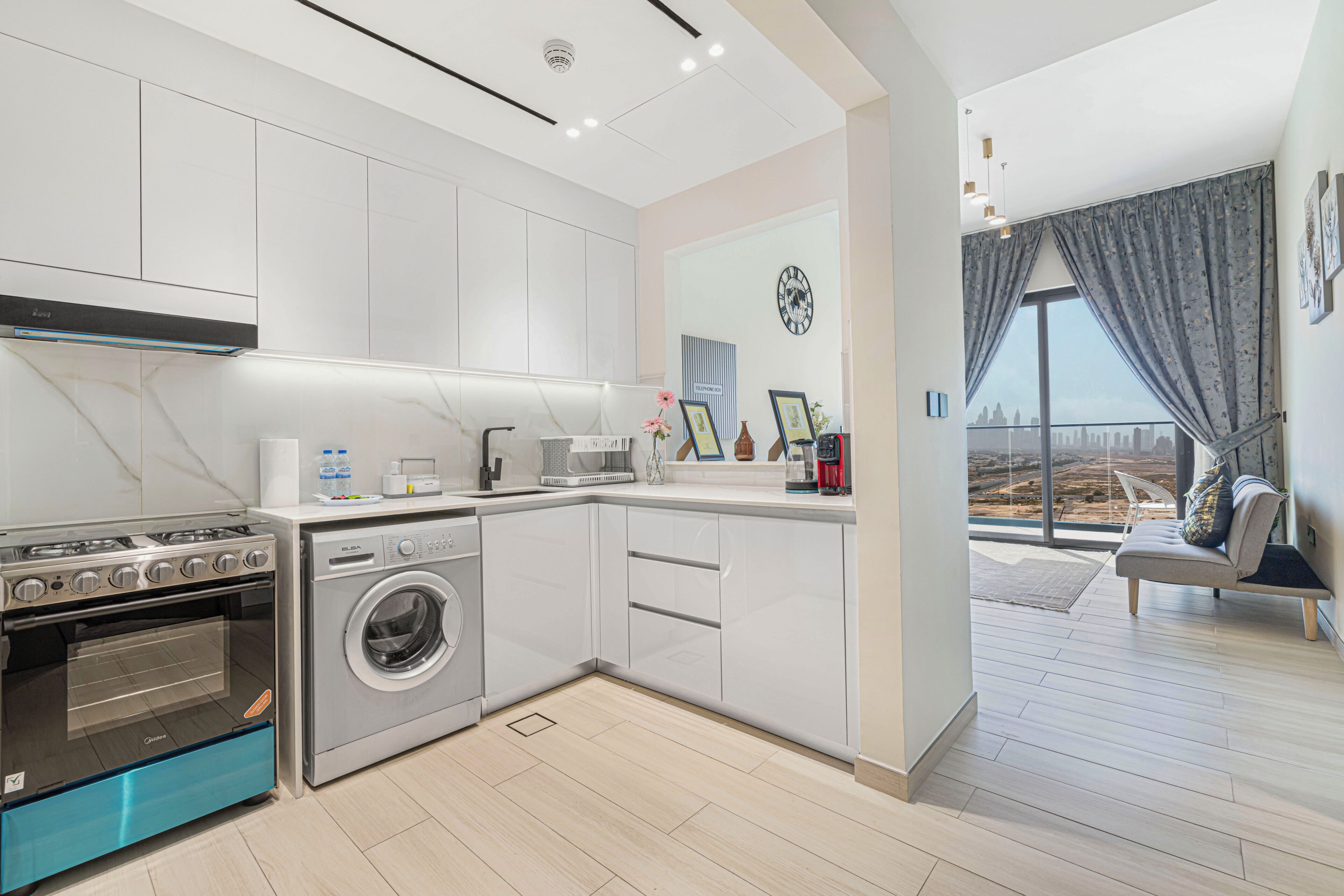 Une cuisine moderne équipée d’un four encastré, d’un lave-linge et d’un coin repas avec vue.