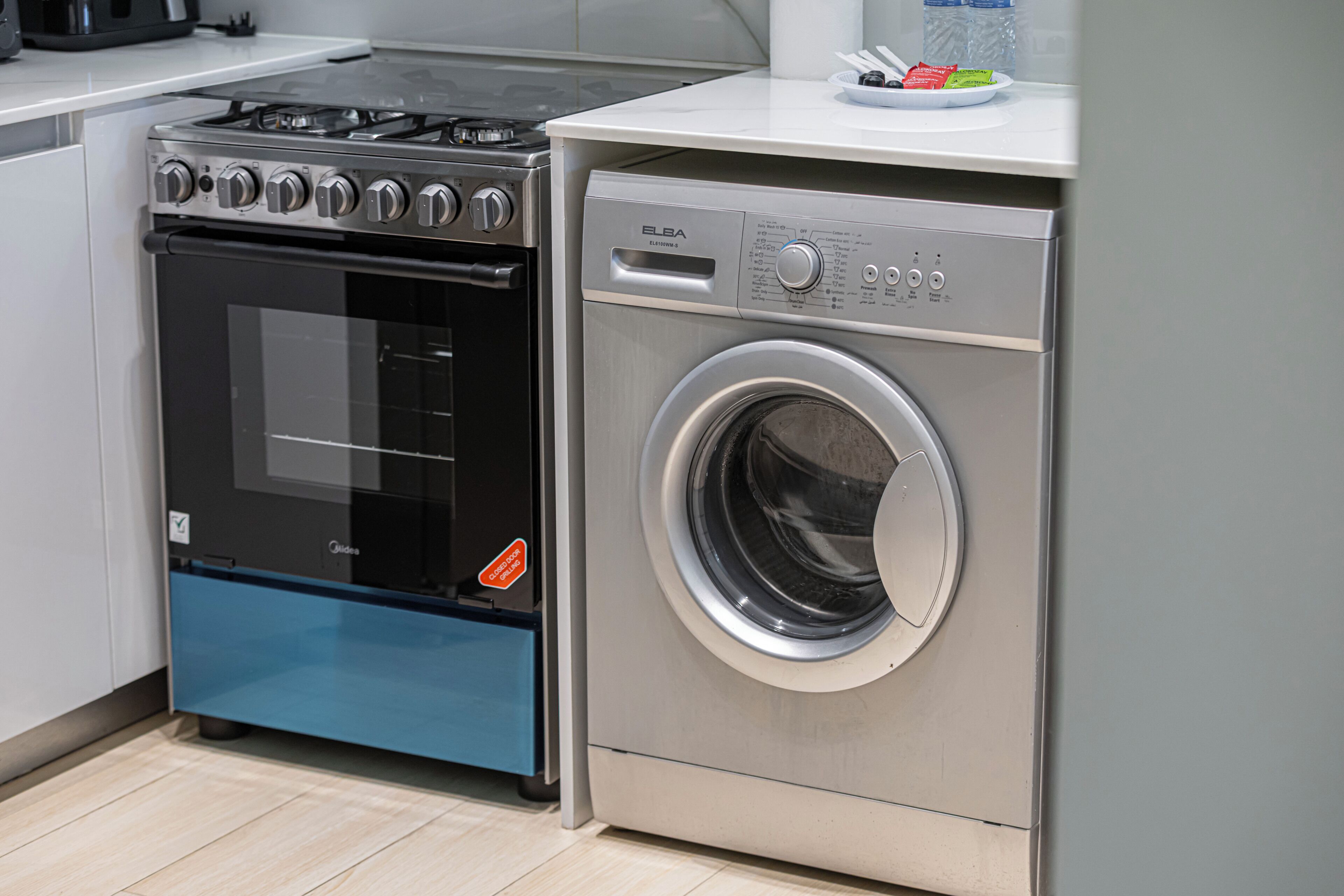 Een kleine keuken met een ingebouwde oven en een voorlader wasmachine.