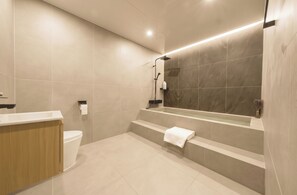 Un baño moderno con ducha, inodoro y tocador.